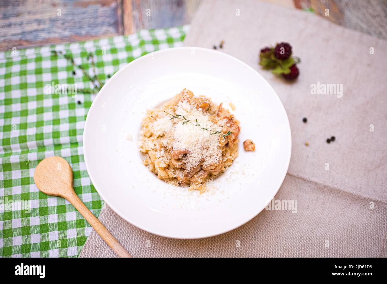 a portion of risotto with seafood and parmesan cheese grated on top. one plate on the table top view. Stock Photo
