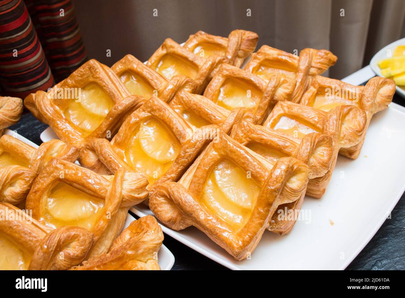 Puff pastry with peach jelly. Layout on the buffet table. Crispy dough. Fresh baked goods. Stock Photo