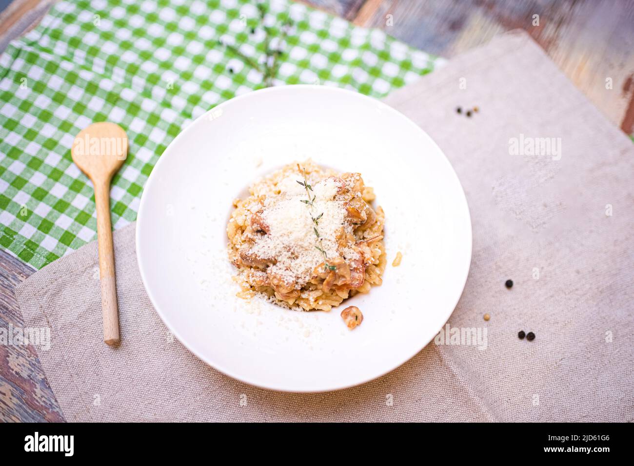 a portion of risotto with seafood and parmesan cheese grated on top. one plate on the table top view. Stock Photo