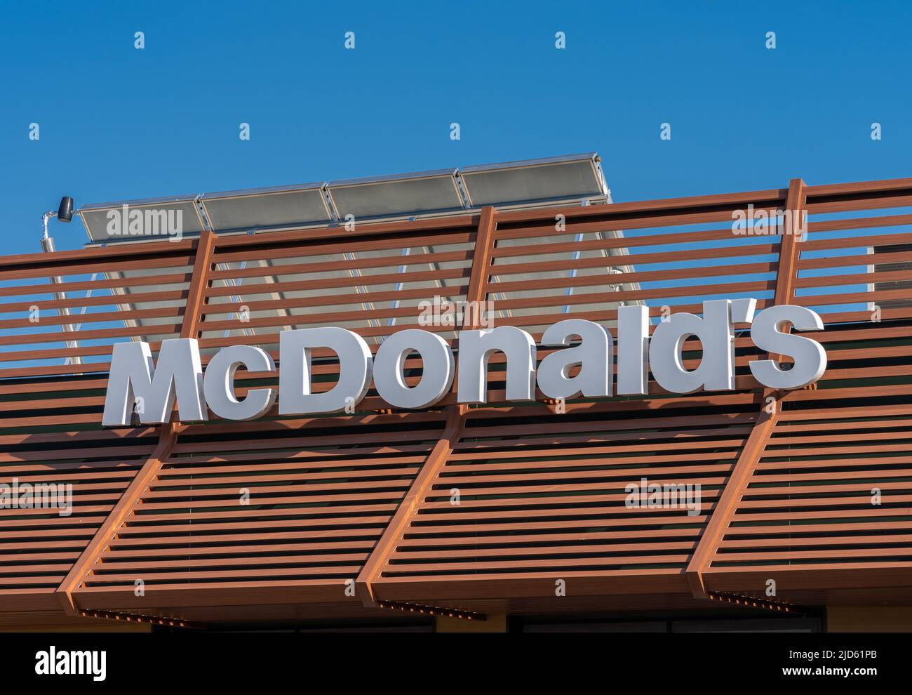 Savigliano, Italy - June 16, 2022: McDonald's sign on restaurant on blue sky, McDonald's is the largest hamburger fast food chain Stock Photo
