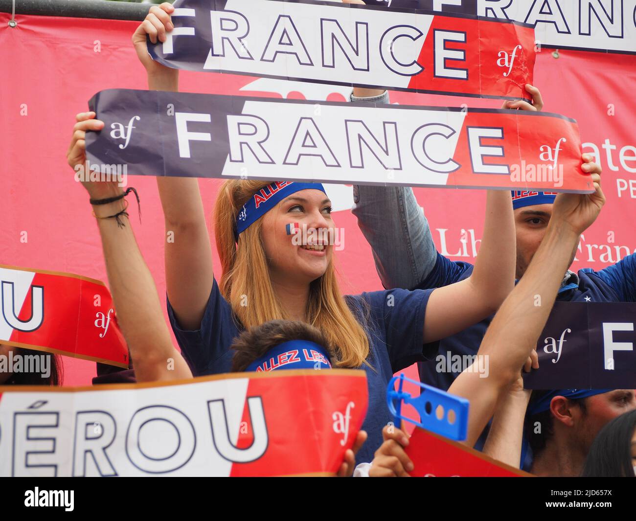 A blonde French girl, handling banners, fan of the France Football team watching the Russia WC 2018 Peru vs. France match at the Alliance Francaise in Miraflores. Peru is participating in the FIFA soccer World Cup 2018 for the first time in 36 years. Stock Photo