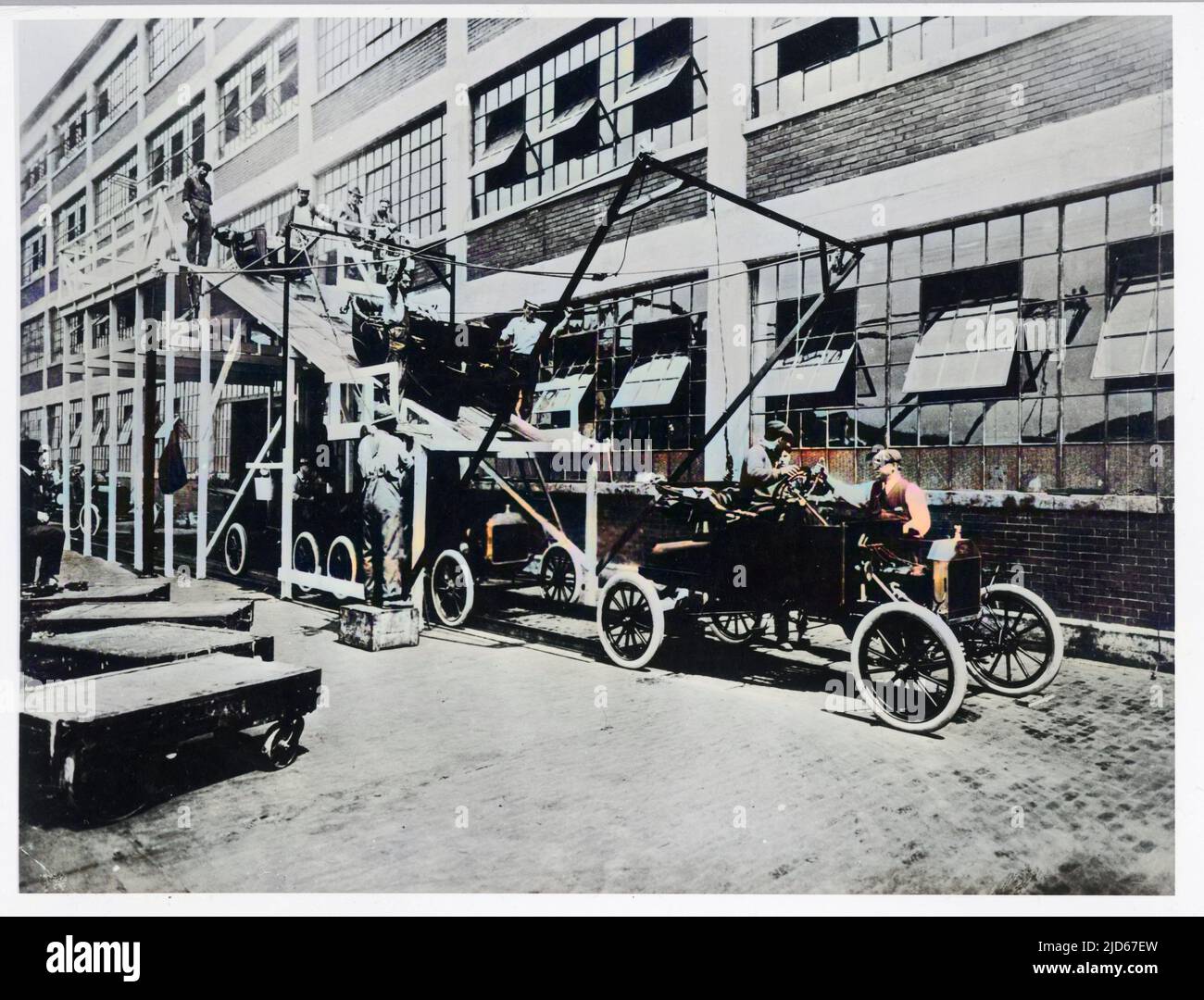 Working on the Ford assembly line in Detroit, USA. Here, car bodies are united with the chassis. Colourised version of : 10018142       Date: 1909 Stock Photo