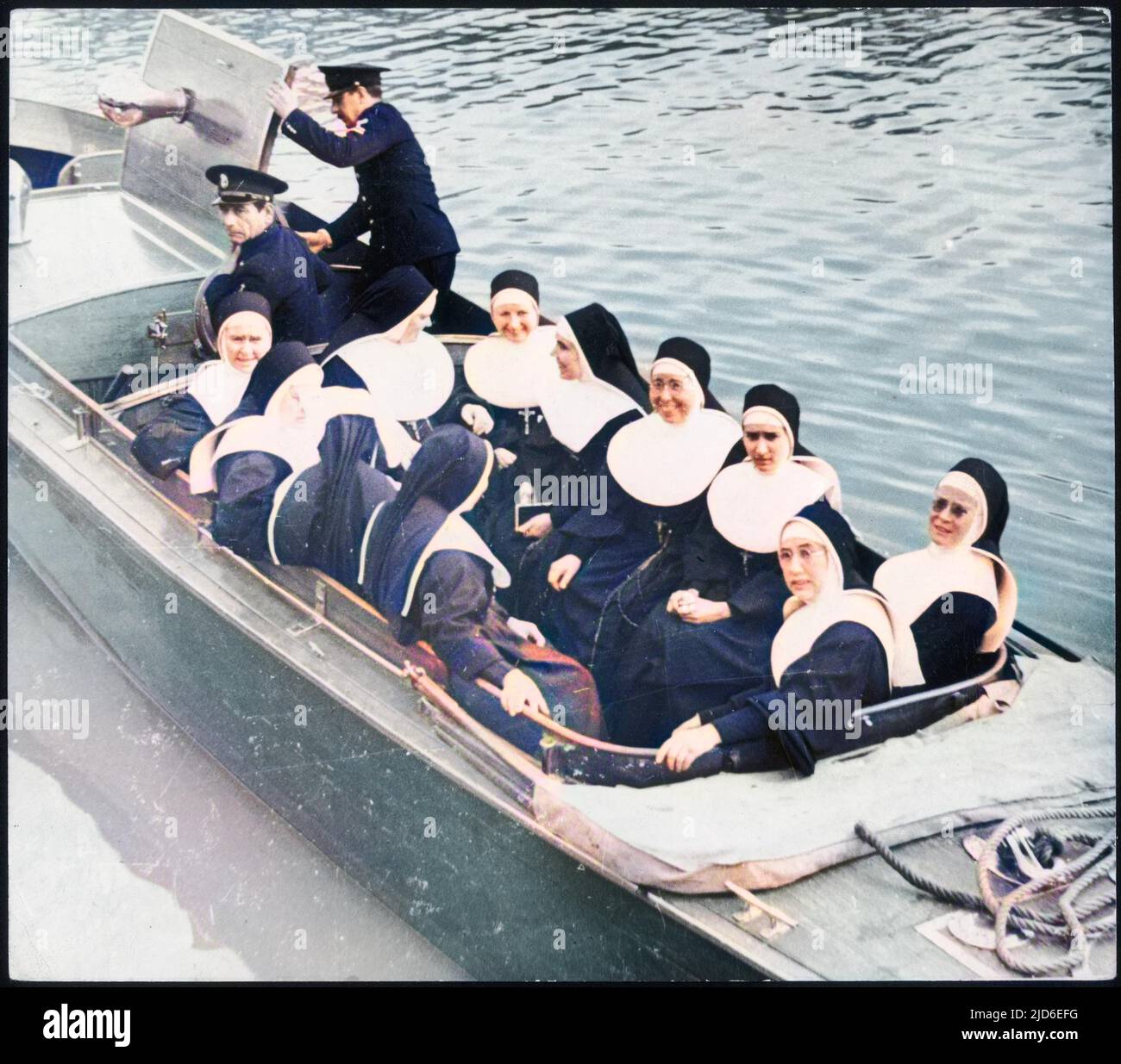 A group of nuns in the launch from the Christo Rey. When the floating church goes inland the sisters go ashore to administer help and advice. Colourised version of : 10145074       Date: 1930s Stock Photo