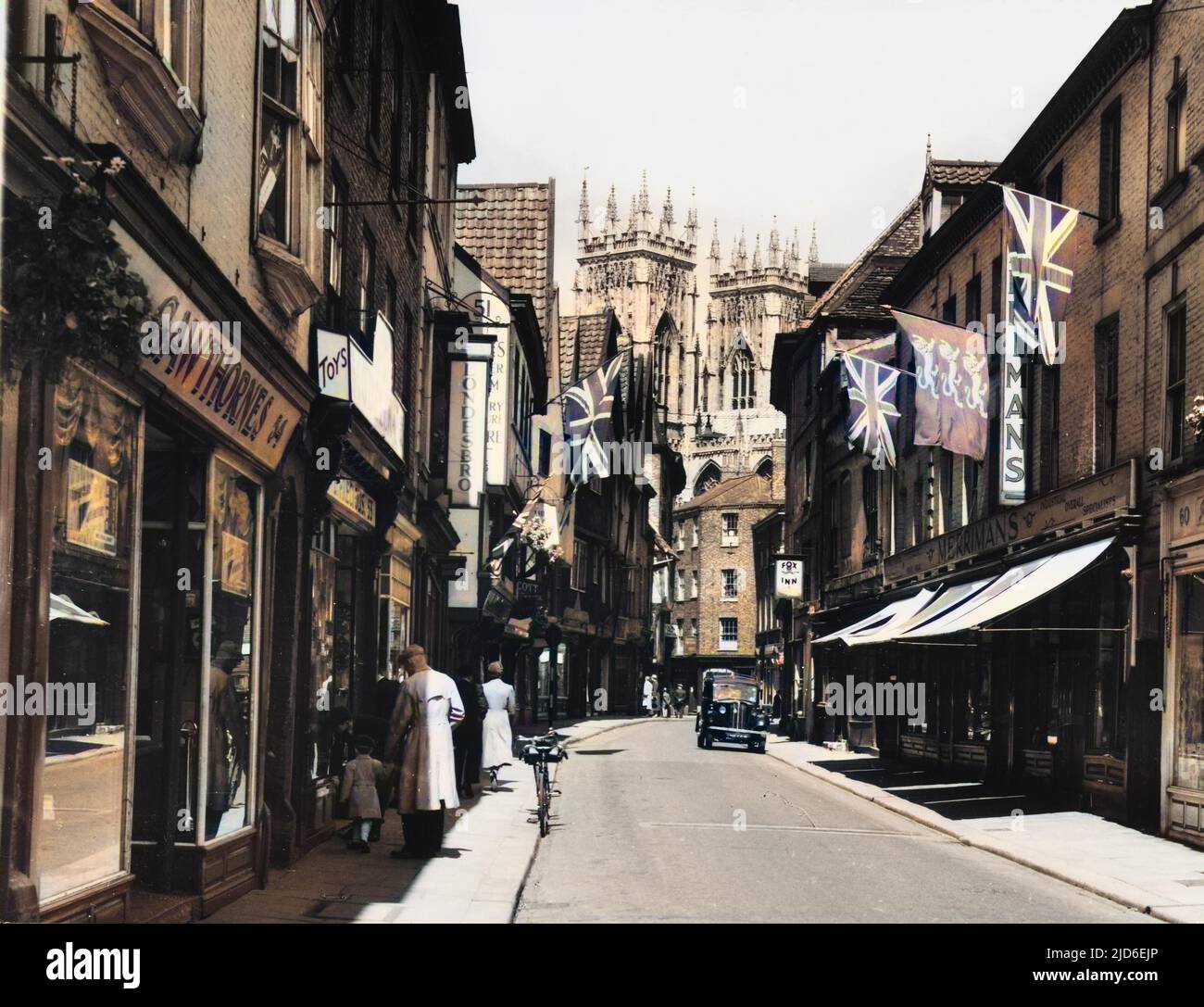 A view of Petergate, York, during festival time, with the towers of the Minster in the background. Colourised version of : 10154566       Date: 1950s Stock Photo