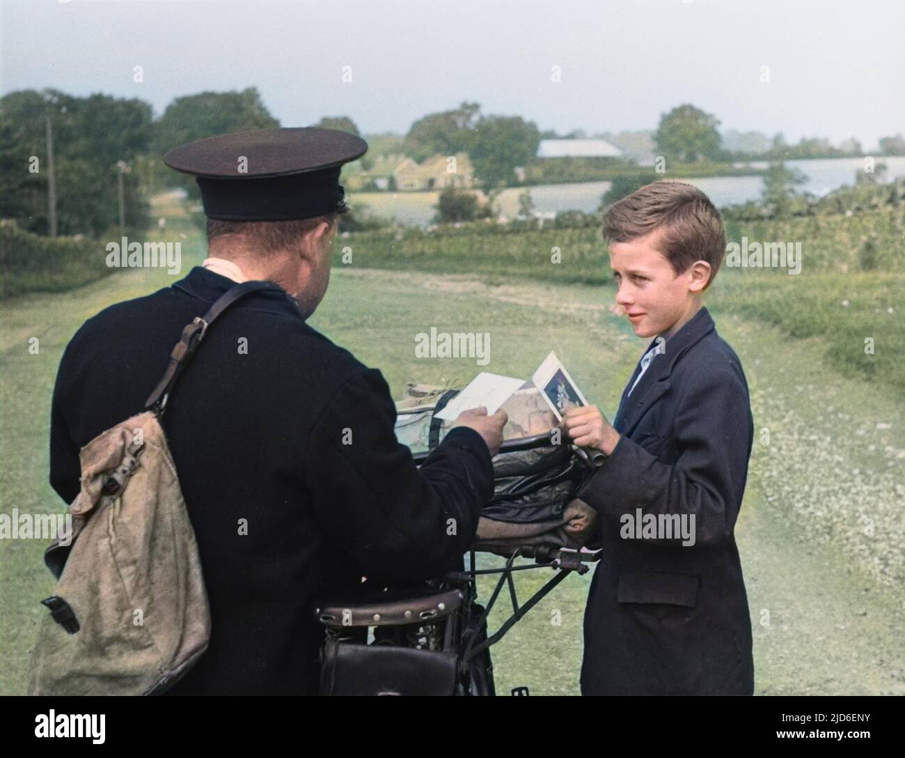 A country postman in Ireland delivers a postcard to a lucky boy. Colourised version of : 10160673       Date: 1930s Stock Photo