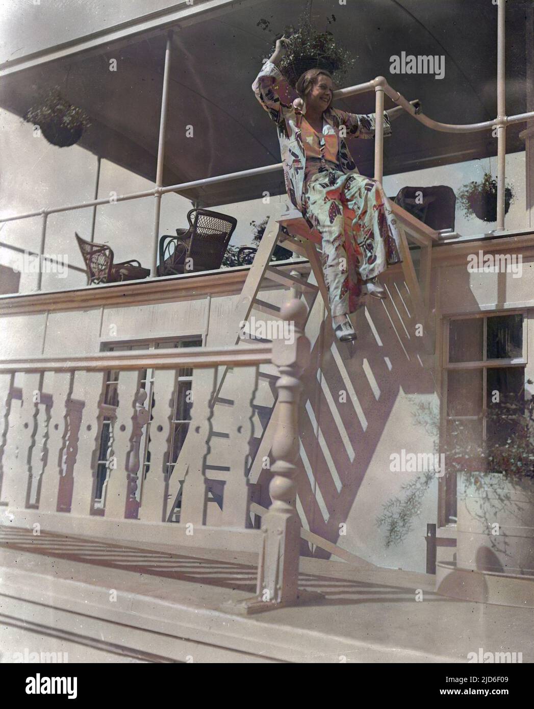 a-girl-wearing-a-floral-pyjama-trouser-suit-poses-on-the-ladder-of-a