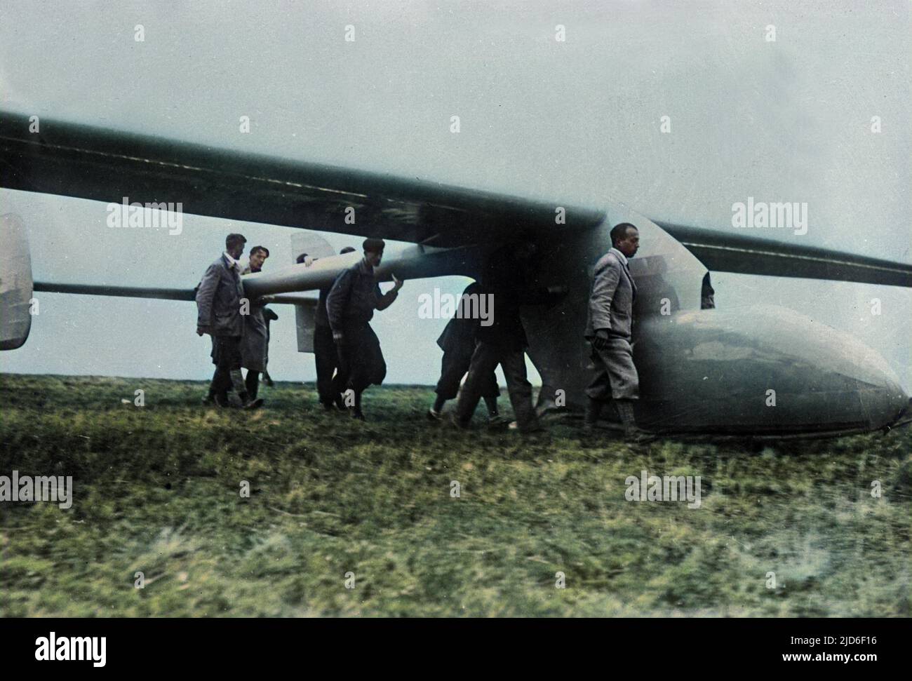 A group of men examine a large German glider plane, a Kupper Ku4