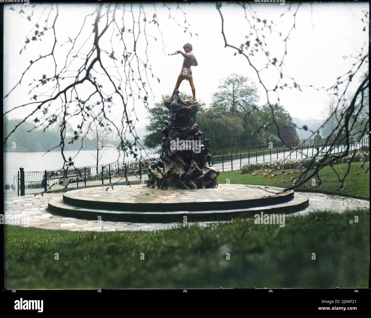 The Peter Pan statue was erected on 1 May 1912 in Kensington Gardens and sculpted by George Frampton. Peter Pan entered London along the Serpentine in the story. Colourised version of : 10162208       Date: 1930s Stock Photo