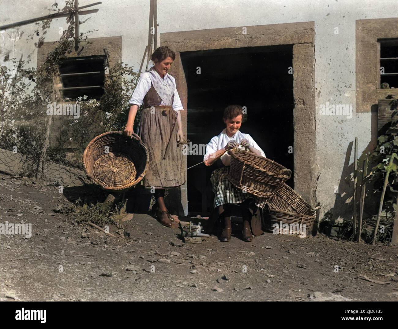Two German peasant women basketmakers. Colourised version of : 10162014       Date: early 1930s Stock Photo