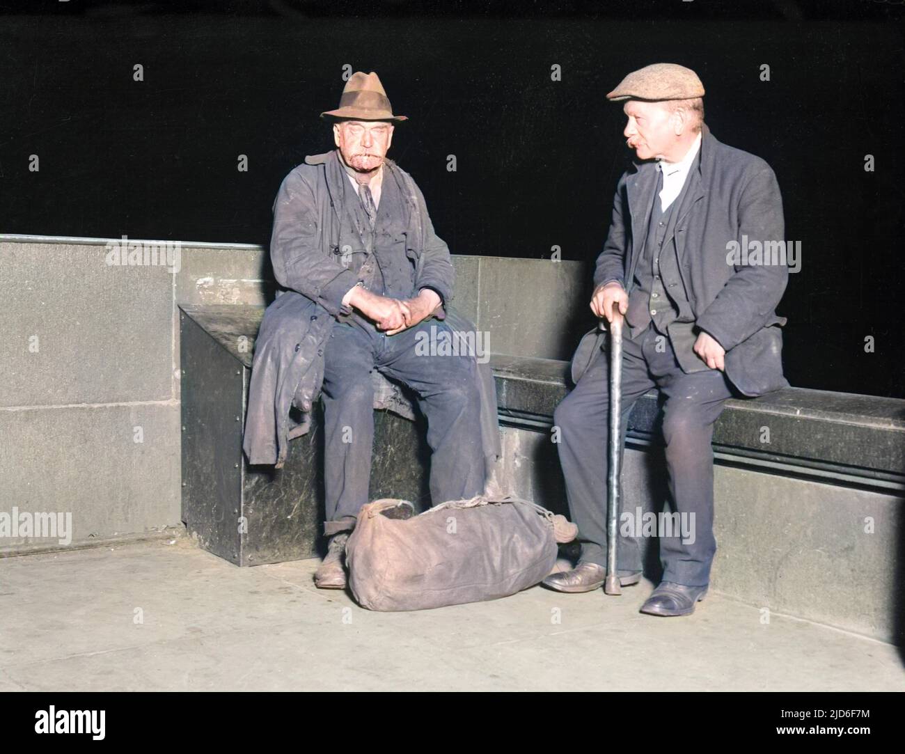 Two old tramps sitting together at night on the Embankment, London, England. Colourised version of : 10164128       Date: early 1930s Stock Photo