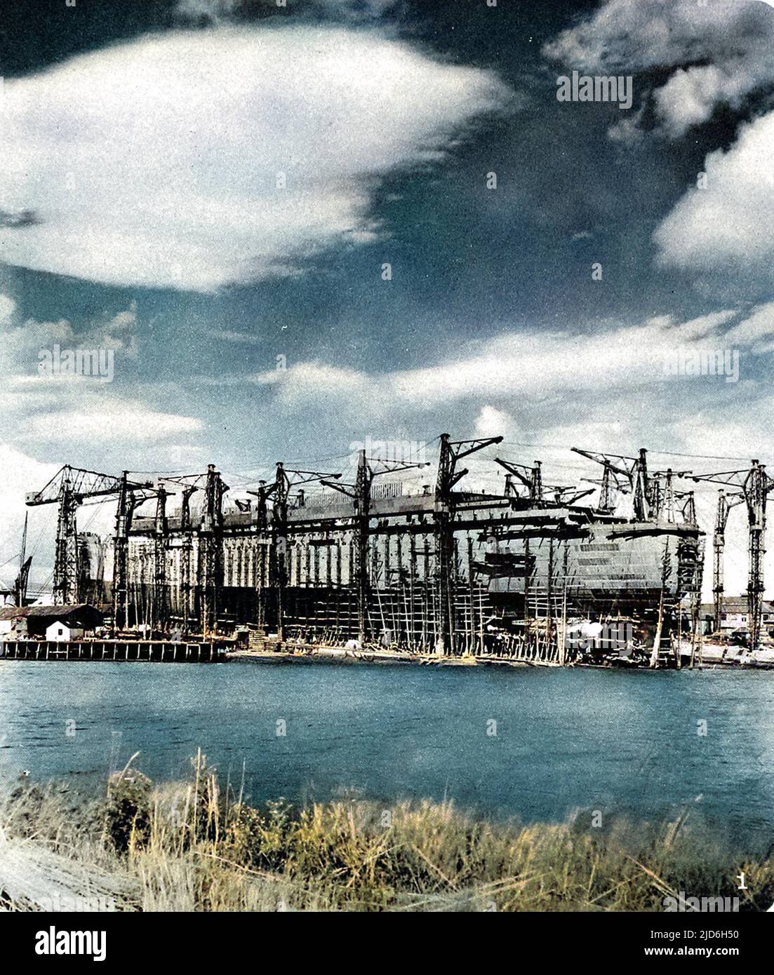 Cunard White Star Liner, R.M.S. 'Queen Mary', photographed from across the Clyde, under construction at the John Brown shipyard, Clydebank, the ship was known as 'Hull Number 534' until her launch on 26th September that year. Colourised version of: 10216344       Date: 1934 Stock Photo