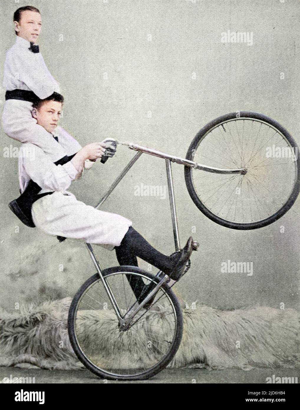 Two of the Kaufmann troupe performing a bicycle trick at the London Hippodrome, September 1901. Colourised version of: 10218885       Date: 1901 Stock Photo