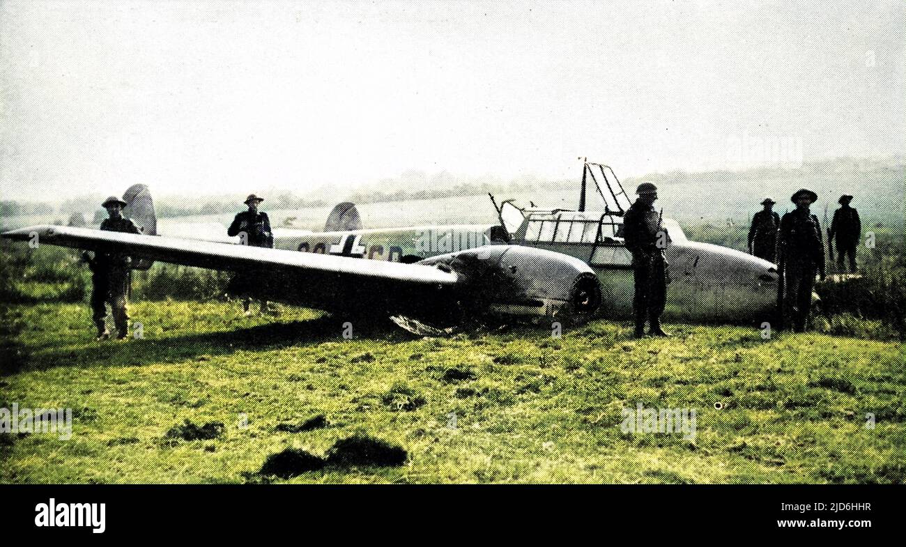 German Messerschmitt Me-110 fighter-bomber, which crash-landed near Hastings after being shot up by a British fighter, during the summer of 1940. A number of British soldiers can be seen guarding the airplane. Colourised version of: 10220002       Date: 1940 Stock Photo