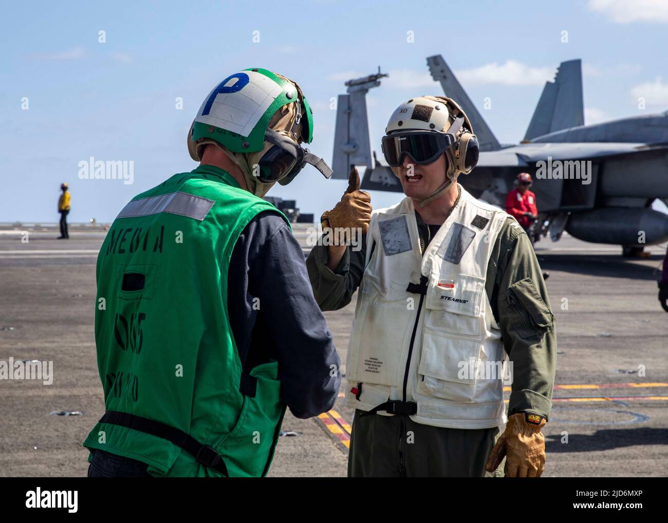 220617-N-OL632-2031 ATLANTIC OCEAN (June 17, 2022) Capt. Nick DeLeo, executive officer of the Nimitz-class aircraft carrier USS George H.W. Bush (CVN 77), right, speaks with Senior Chief Mass Communications Specialist Dustin Withrow, June 17, 2022. The George H.W. Bush Carrier Strike Group (CSG) is underway completing a certification exercise to increase U.S. and allied interoperability and warfighting capability before a future deployment. The George H.W. Bush CSG is an integrated combat weapons system that delivers superior combat capability to deter, and if necessary, defeat America's adver Stock Photo