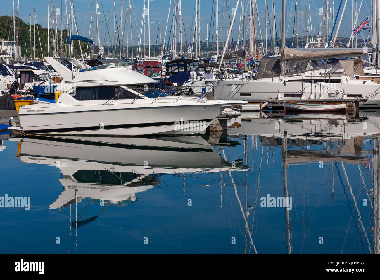 Brixham Harbour & Marina, Devon, England, UK –tethered and anchored boats casting reflections on mirror-like sea Stock Photo