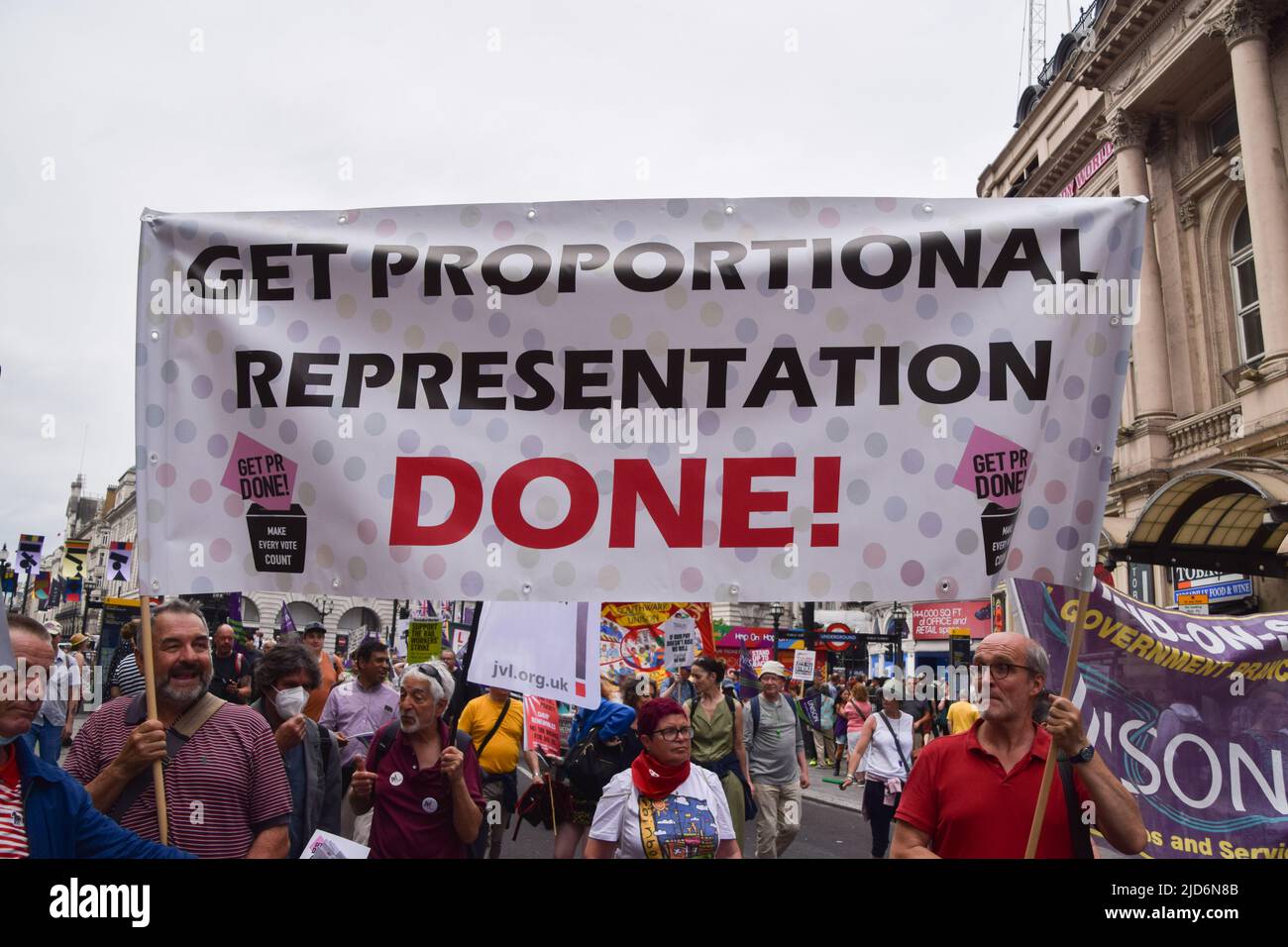 London, UK. 18th June, 2022. Protesters hold a banner which reads 'Get proportional representation done' during the demonstration in Piccadilly Circus. Thousands of people and various trade unions and groups marched through central London in protest against the cost of living crisis, the Tory Government, the Rwanda refugee scheme and other issues. Credit: SOPA Images Limited/Alamy Live News Stock Photo
