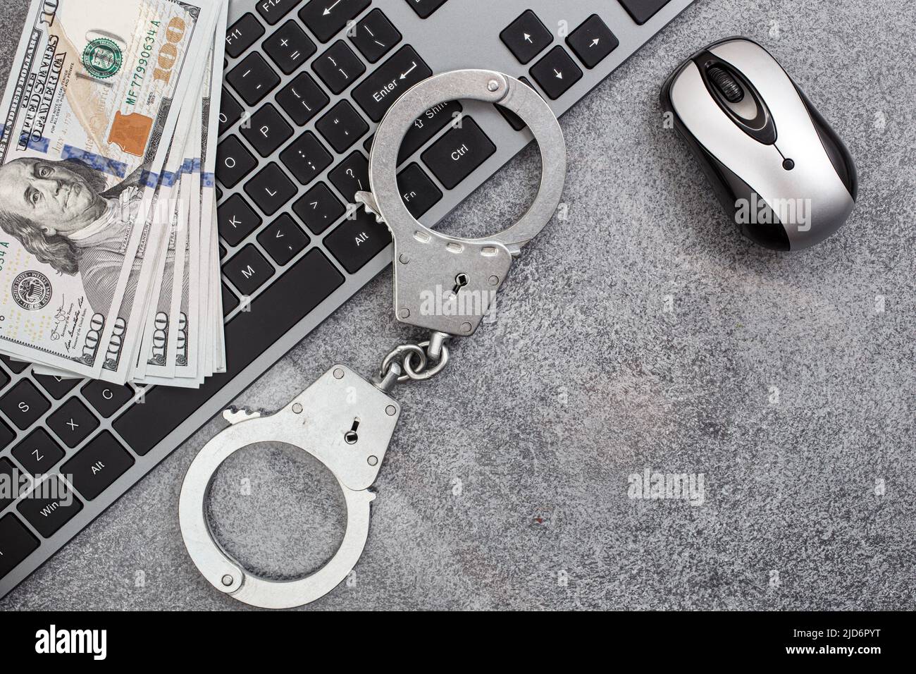 Handcuffs keyboard and dollars above Stock Photo