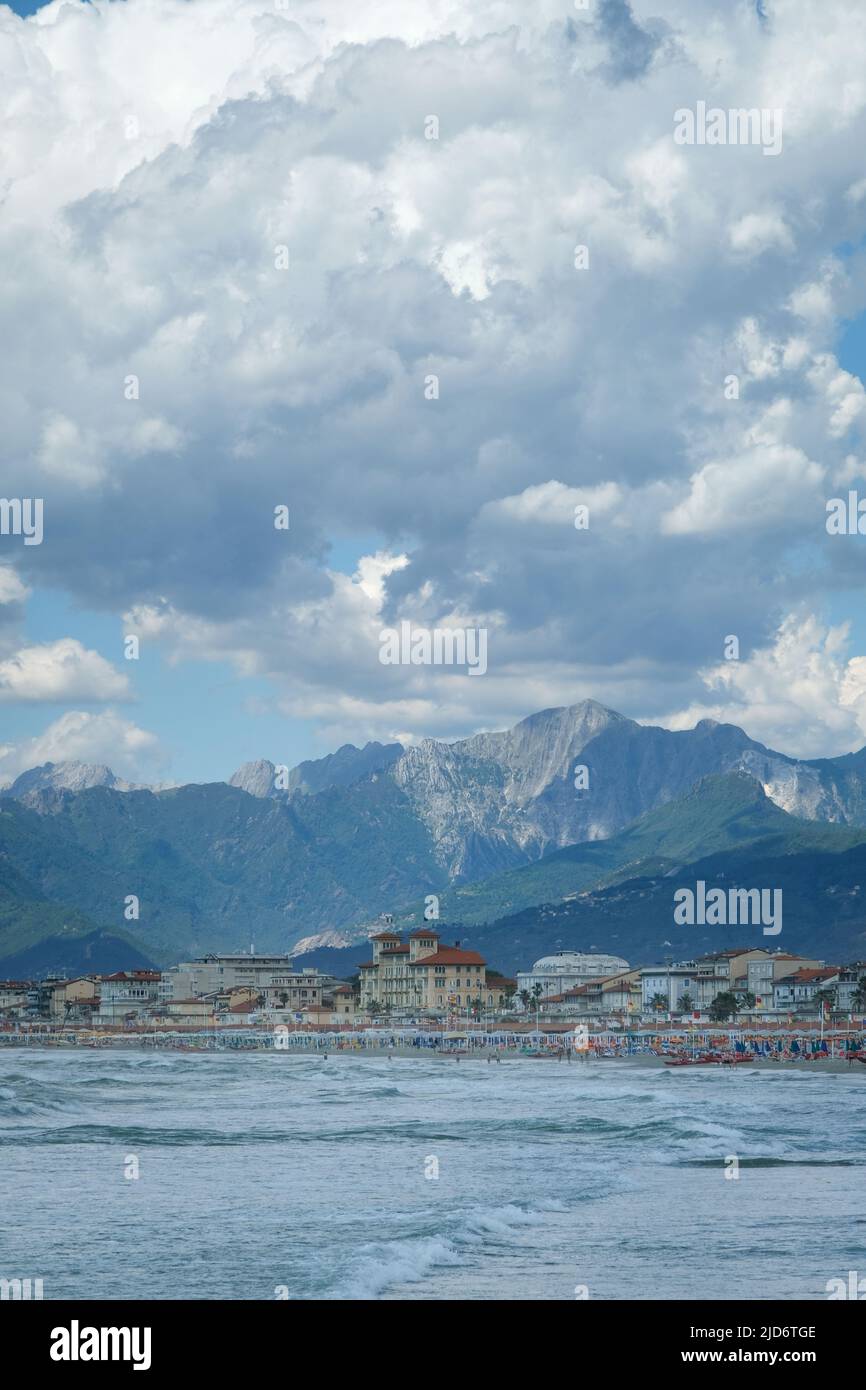 Dramatic clouds and distant mountains tower over the seaside city of Viareggio, Italy. Stock Photo