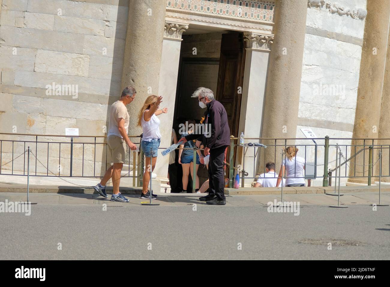 Pisa, Italy - June 8, 2022: Man checks tourists with metal detecting wand before enterin Leaning Tower of Pisa. Stock Photo