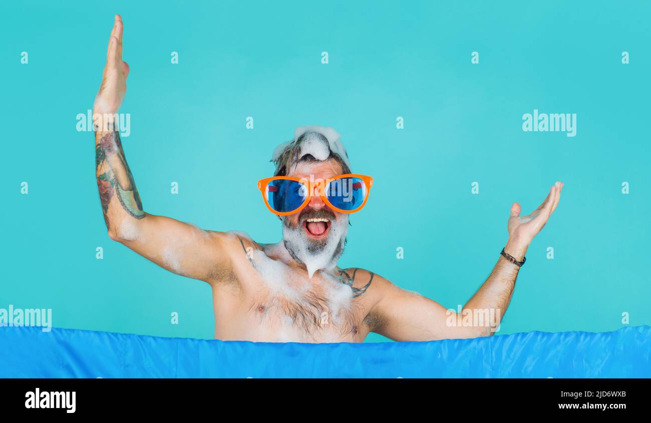 Happy man in funny glasses taking shower. Everyday hygiene. Male