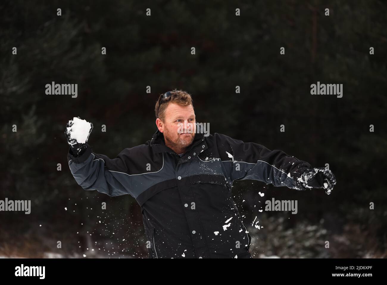 Adult man playing in winter snowball fight Stock Photo