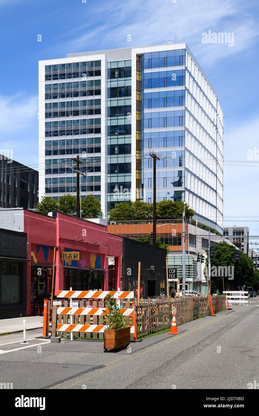 Seattle - June 07, 2022; Amazon Apollo high rise building rises behind street side seating on 9th Avenue in Seattle on sunny day Stock Photo