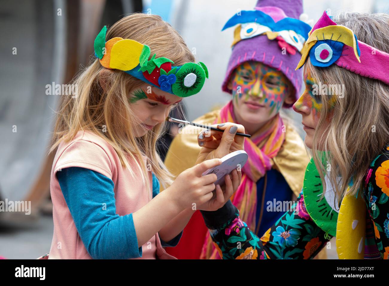 Seattle, Washington, USA. 18th June, 2022. Gina paints the face of her daughter Juniper as they prepare for the Fremont Solstice Parade to begin. The iconic, annual parade returned after a three-year hiatus due to the coronavirus pandemic. Credit: Paul Christian Gordon/Alamy Live News Stock Photo