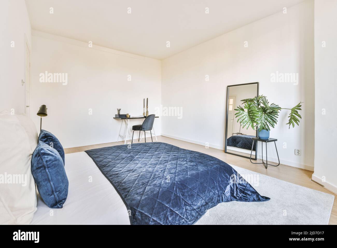 Comfortable bed with colorful pillows and a warm blanket placed against