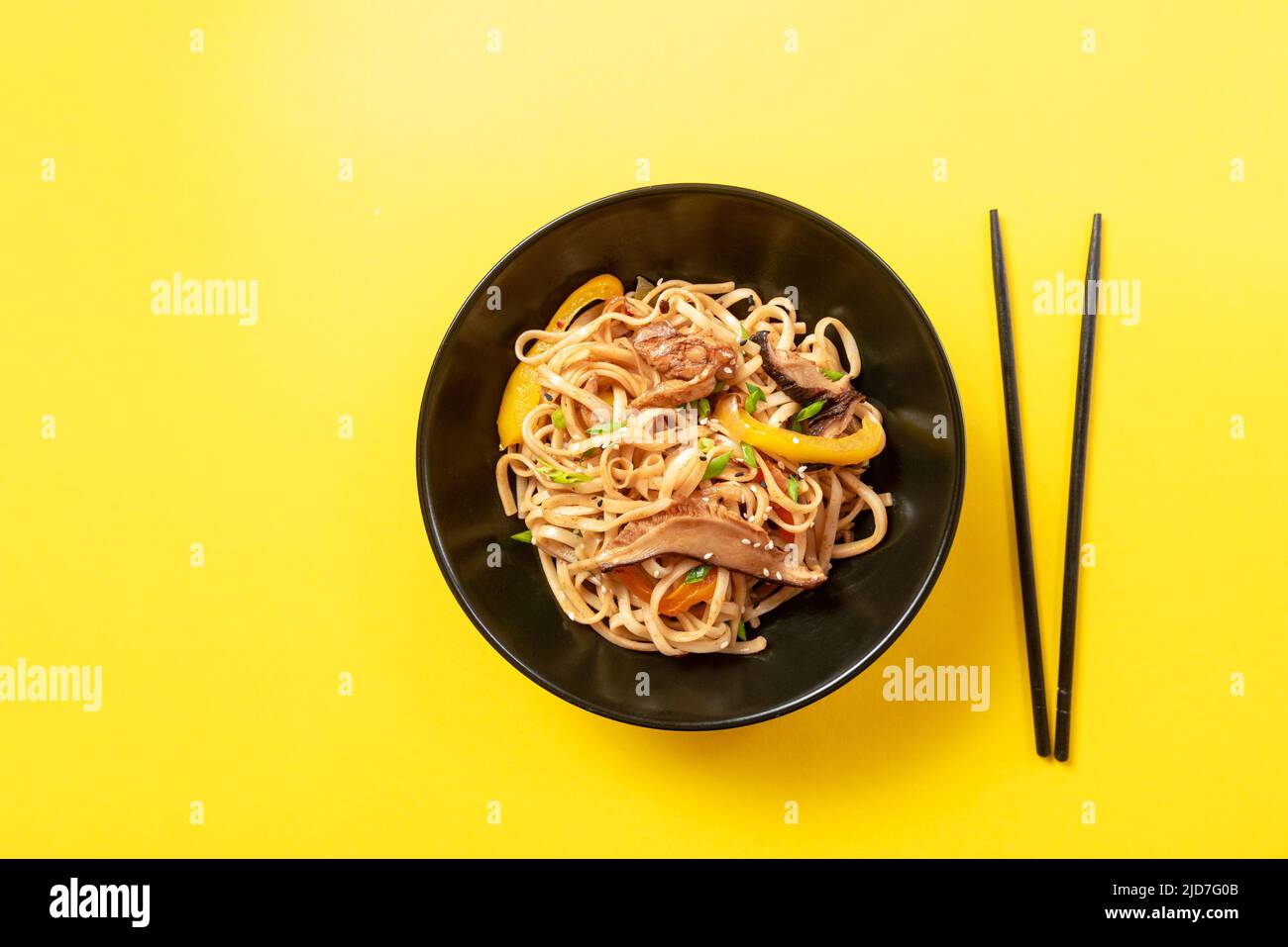 Asian food. Udon noodles with chicken in a black plate Stock Photo