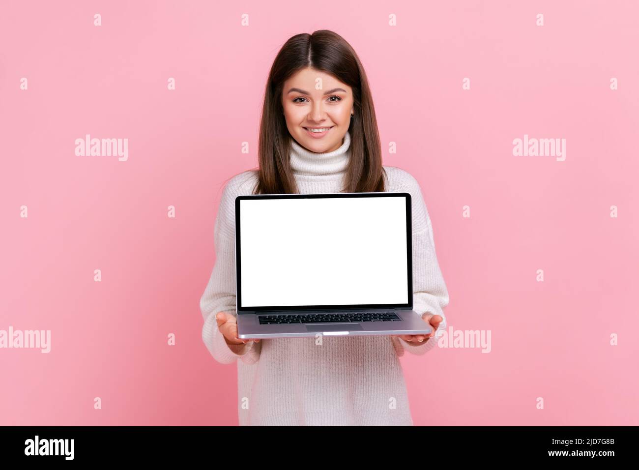Happy smiling female standing with laptop with blank white screen for ...