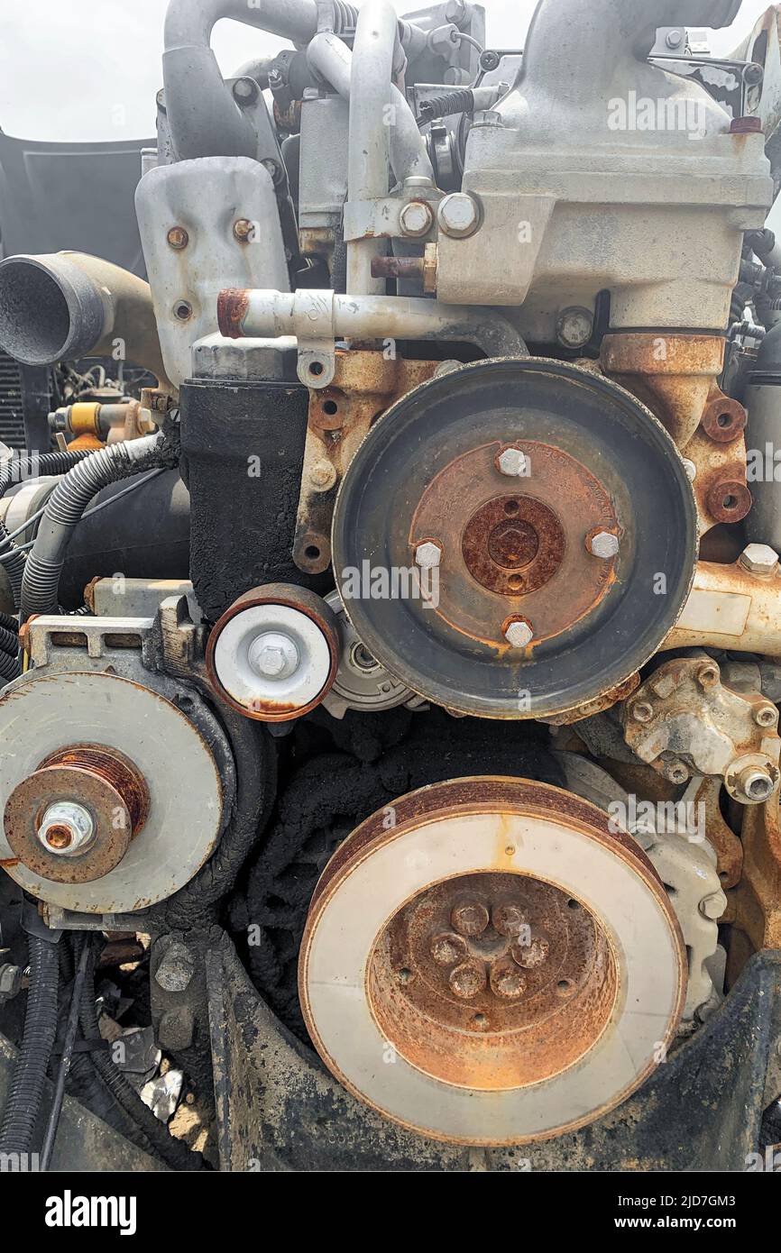 Closeup of broken engine removed from a car, reusing spares of wrecked vehicles, rusty motor of crashed truck on car dump, Stock Photo