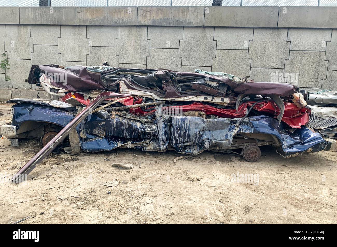 A pile of compressed cars going to be shredded, crushed junk vehicles on scrapyard Stock Photo