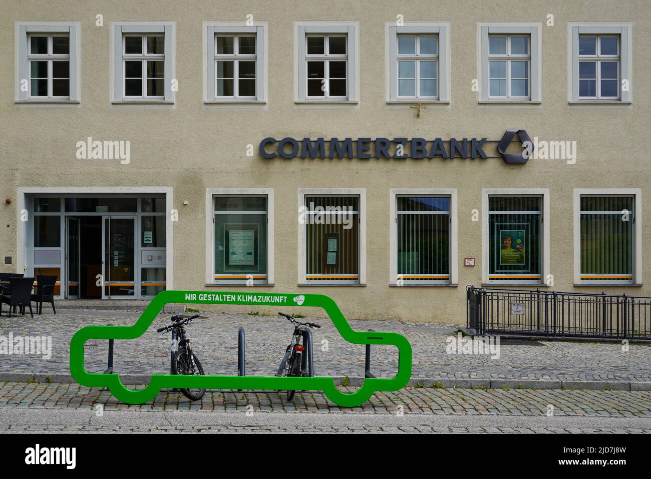 A Commerzbank branch in Ravensburg, in front a green bicycle rack with the slogan: We are creating climate future, Baden-Württemberg, Germany, 6.6.22 Stock Photo
