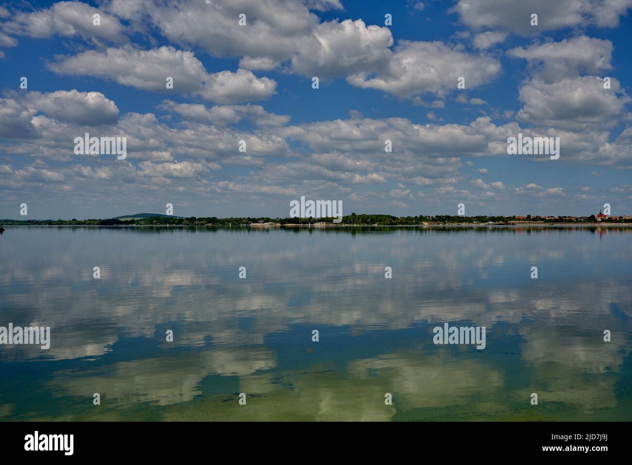 Blue sky with white clouds reflecting on the water Stock Photo - Alamy