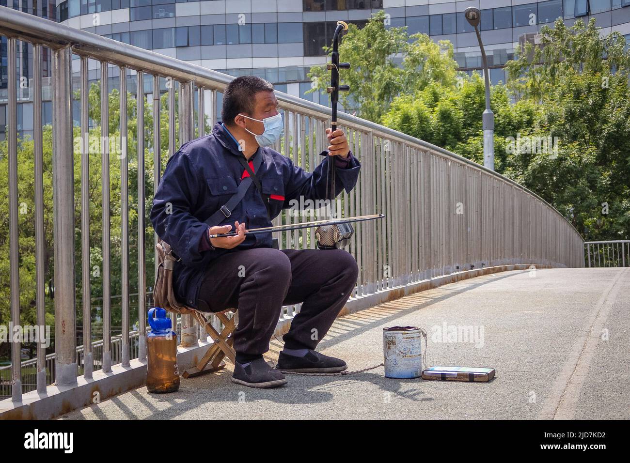 Beijing, China. 05th May, 2022. A beggar plays a traditional Chinese erhu instrument on a Beijing street, China on 05/05/2022 by Wiktor Dabkowski Credit: dpa/Alamy Live News Stock Photo