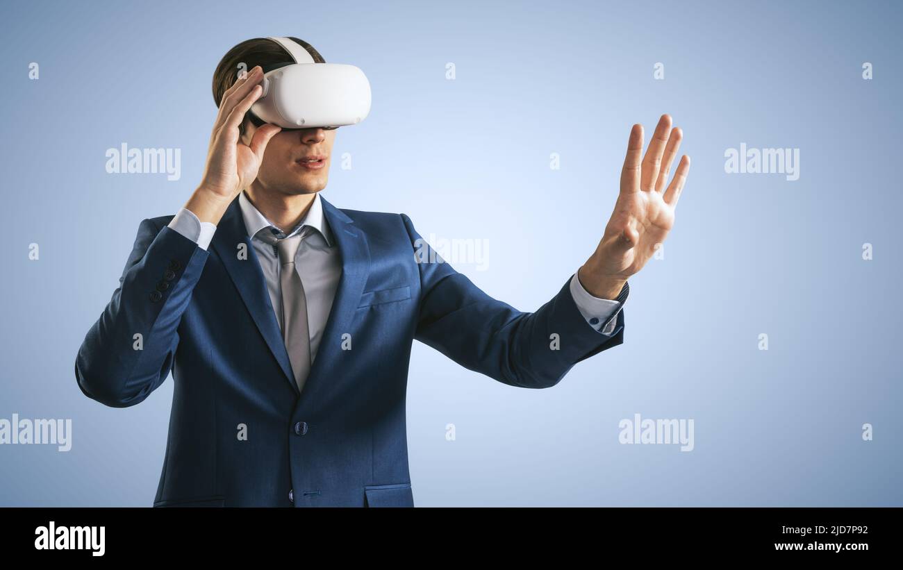 Young man working in virtual reality office in VR glasses, presses his