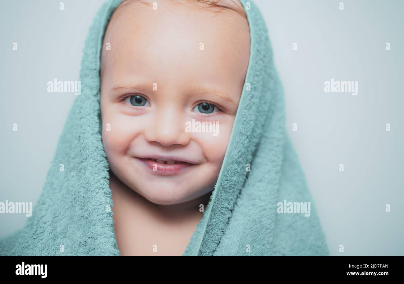 Little baby smiling under a white towel. Smiling baby boy bathing under