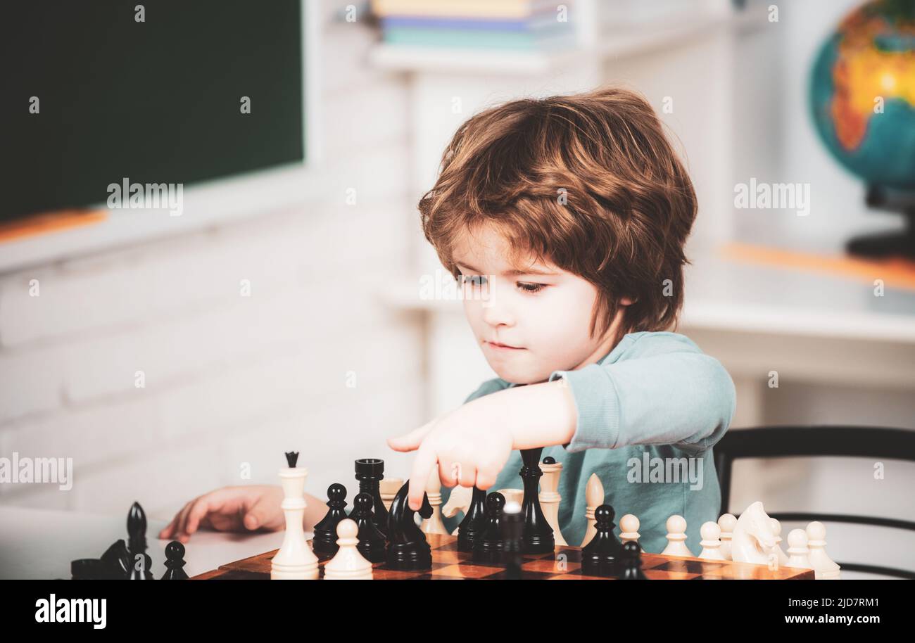 Games and activities for children. Family concept. Boy think or plan about chess game, vintage style for education concept. Kid playing chess in the Stock Photo