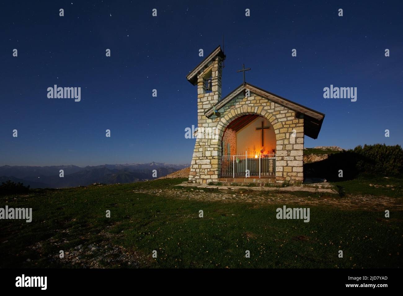 Moon light and stars. Stone chapel on Monte Altissimo di Nago mountain. Prealpi Gardesane Orientali. Trentino. Italy. Europe. Stock Photo