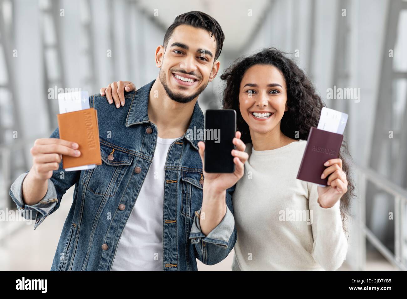 Buy Tickets Online. Arab Couple Standing At Airport And Showing Blank ...