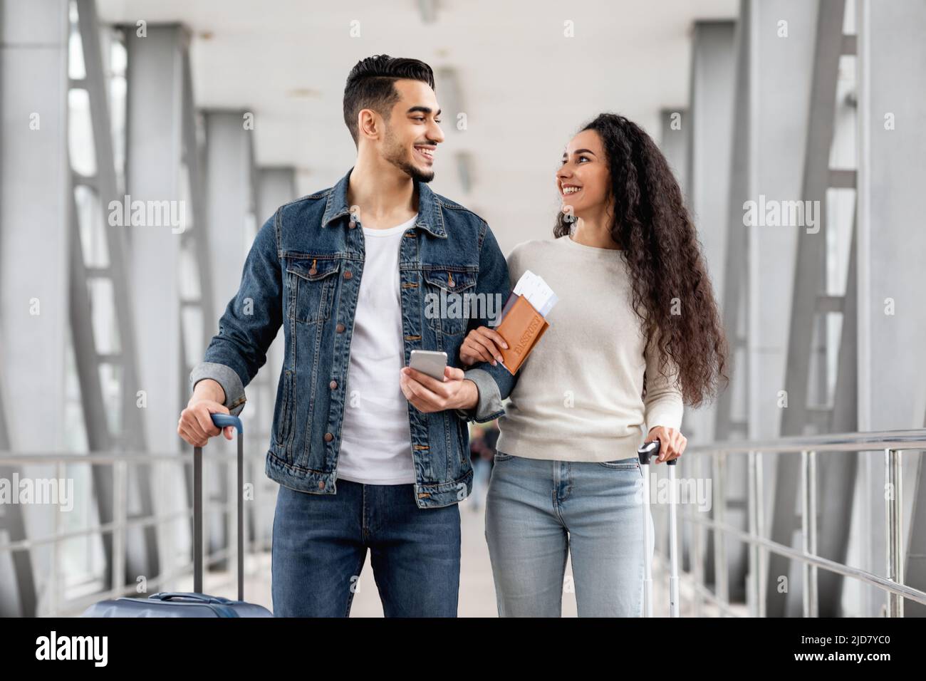 Portrait Of Happy Middle Eastern Couple Walking At Airport With Luggage ...
