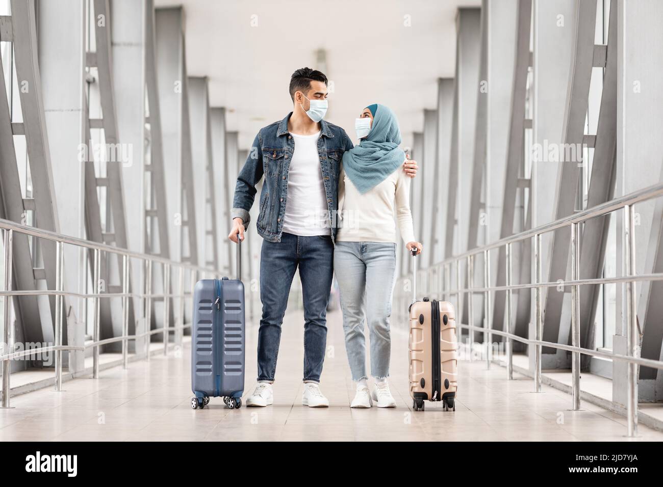 Pandemic Trip. Young Muslim Couple Wearing Masks Standing With Luggage ...