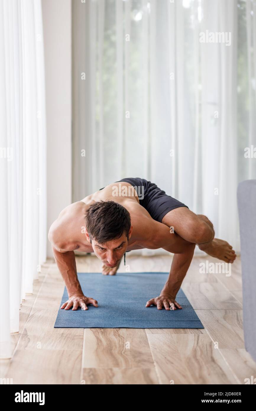 Young man doing strength pilates or yoga workout in the morning Stock Photo