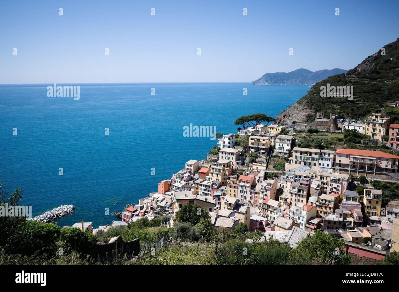 Riomaggiore, Liguria, Italy - April, 2022: Panoramic view from above of small touristic village with typical Italian buildings in Cinque Terre Stock Photo