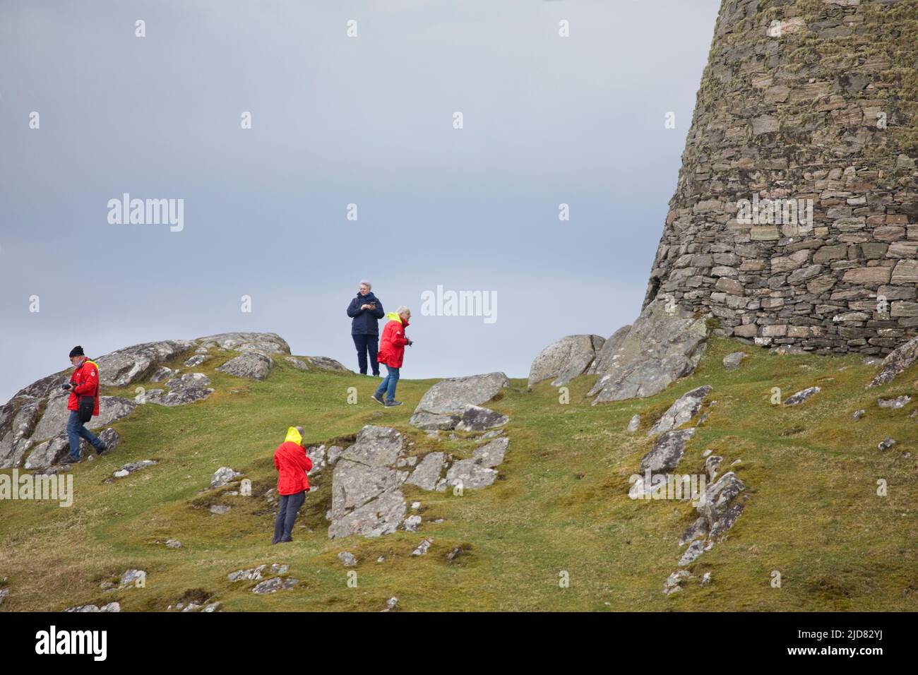 People walking and exploring around the Broch at Dun Carloway on the Isle of Lewis in April, Outer Hebrides, Scotland, United Kingdom Stock Photo