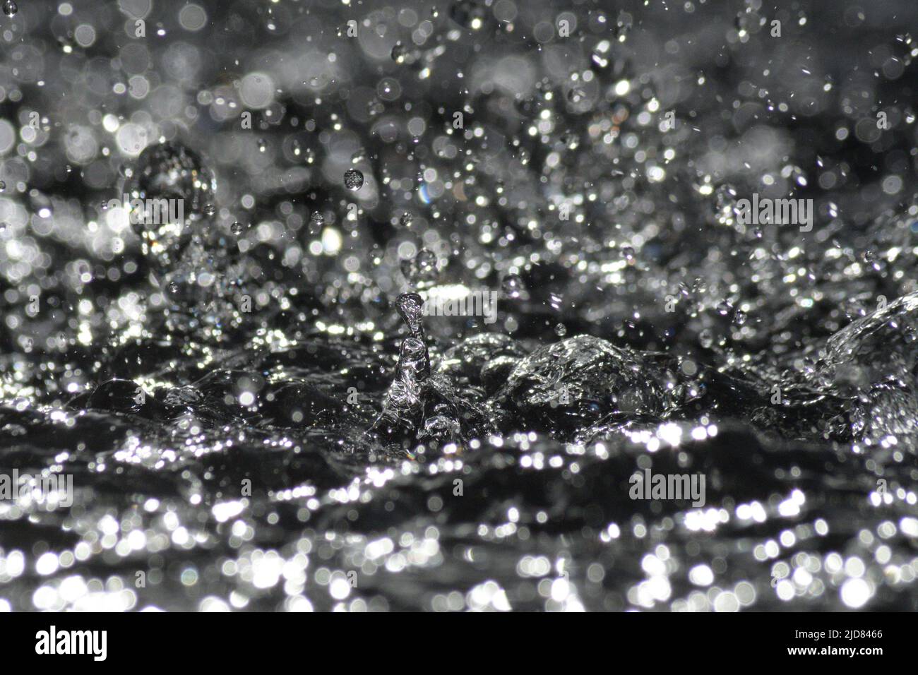 Water drops splashing with force in water Stock Photo - Alamy