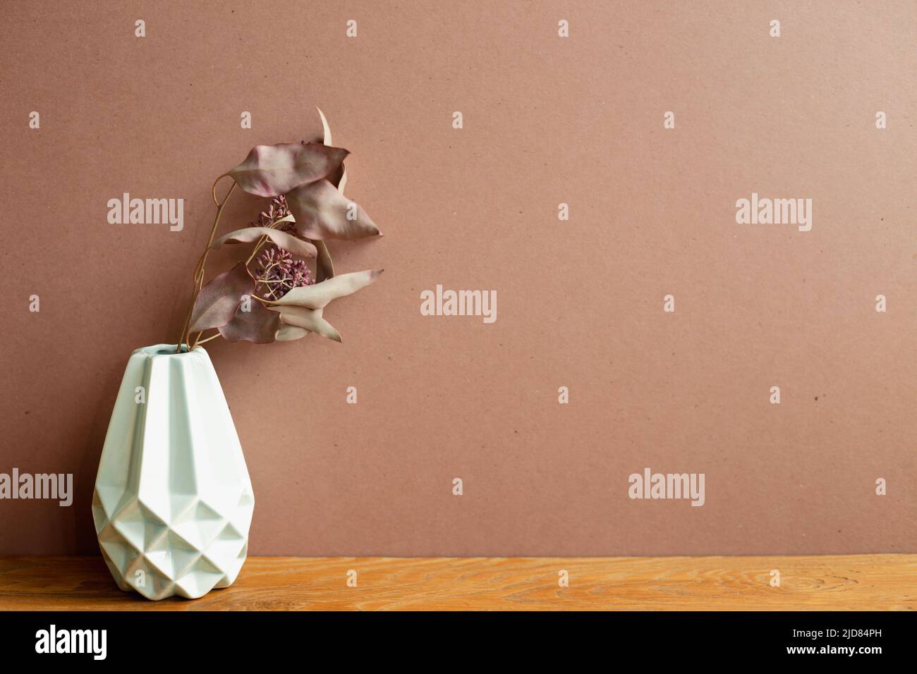 Vase of dry flowers on wooden table. brown wall background. home interior Stock Photo