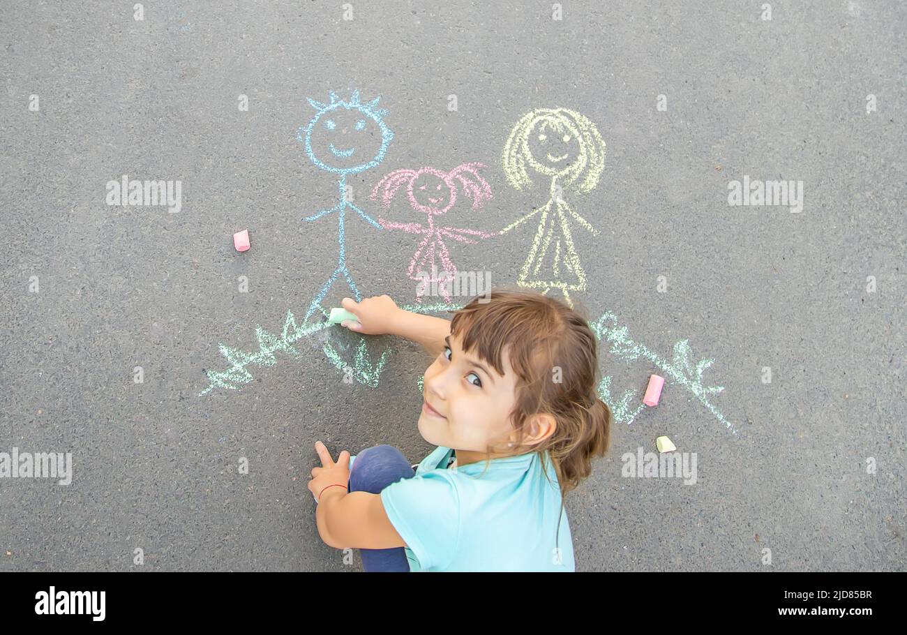 Boy Drawing A Colourful Chalk Picture Of His Family High-Res Stock