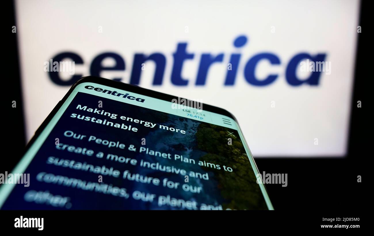 Mobile phone with website of British utility company Centrica plc on screen in front of business logo. Focus on top-left of phone display. Stock Photo