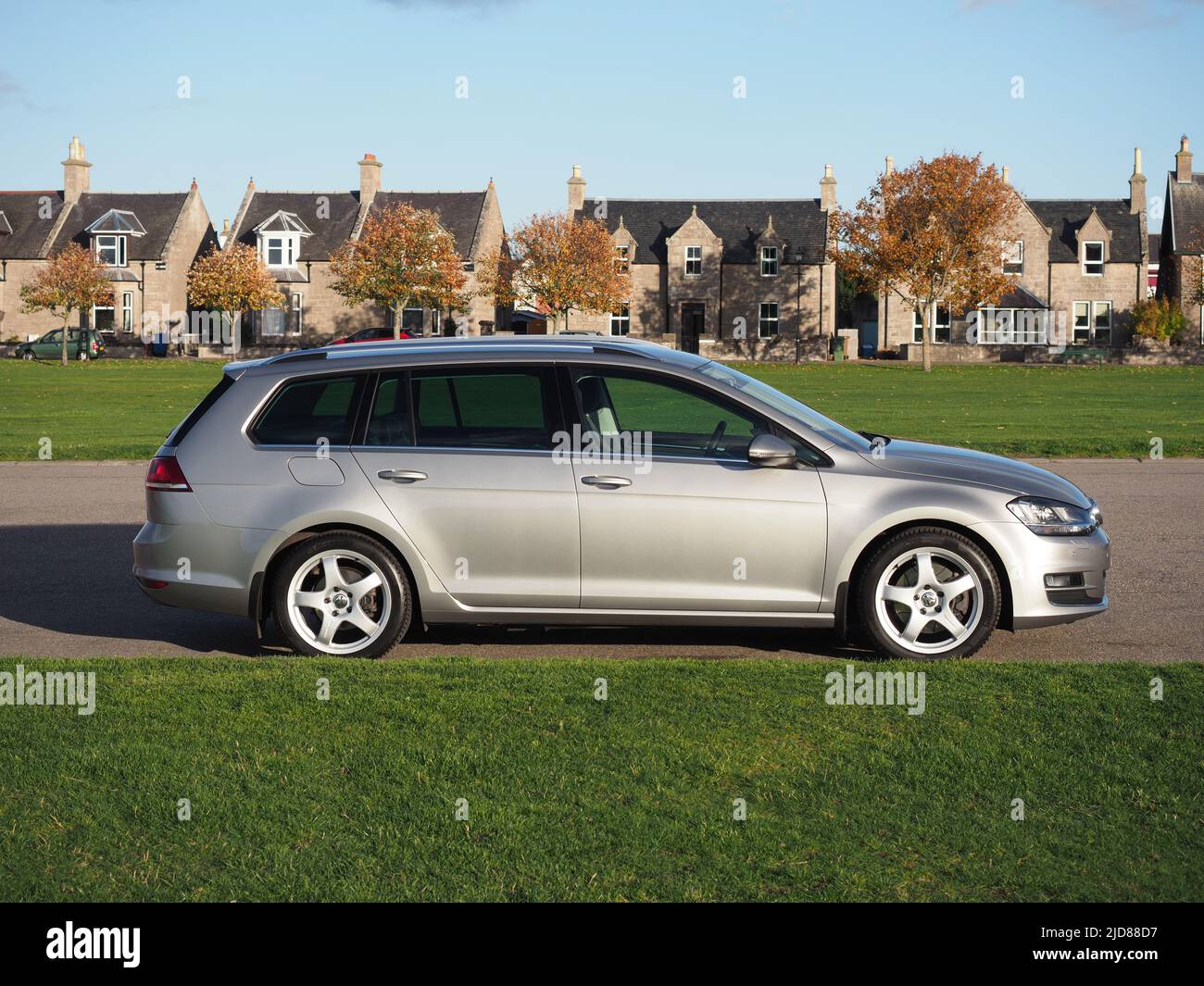 Tungsten silver Volkswagen Golf MK7 estate, variant, with Team Dynamics Pro Race 3 Alloys. Parked next to playing fields. Stock Photo